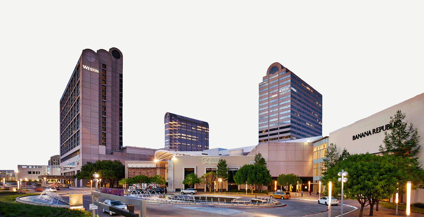 Panoramic view of a shopping complex featuring The Westin hotel, Banana Republic store, and fountains at the entrance, with animated effects enhancing the sky.